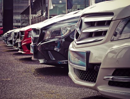 Uma fila de carros estacionados no showroom de uma empresa de carros.