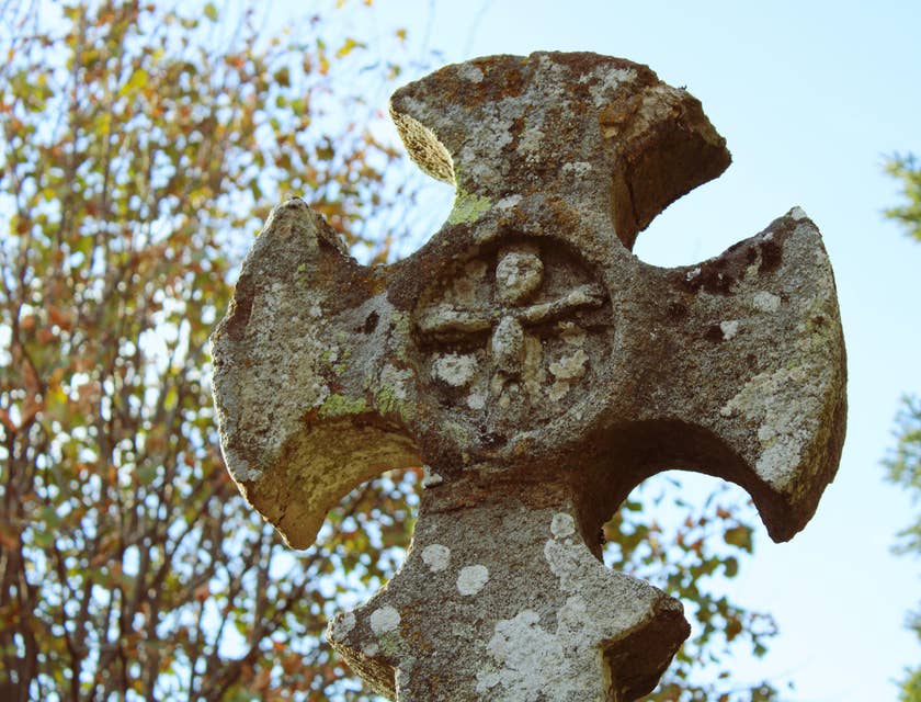 Una grossa croce celtica che si staglia in mezzo ad alcuni alberi.