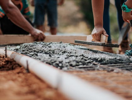 People laying a cement foundation for one of their cement business projects.
