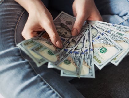 A woman fanning out a handful of cash.