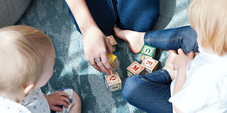 Two children playing with an adult in a childminding business.