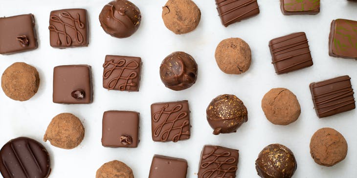 Chocolate spheres and blocks in a glass display case with Japanese price tag.