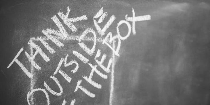A clever chalk drawing of a square and the words "think outside of the box" written over it.