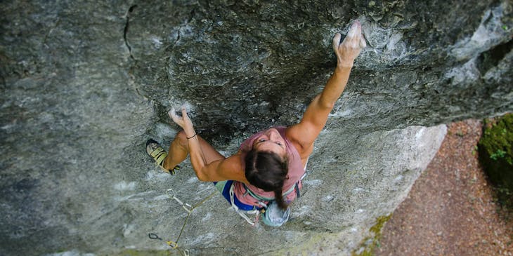 A woman free climbing up a mountain.