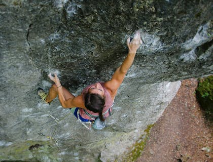 A woman free climbing up a mountain.