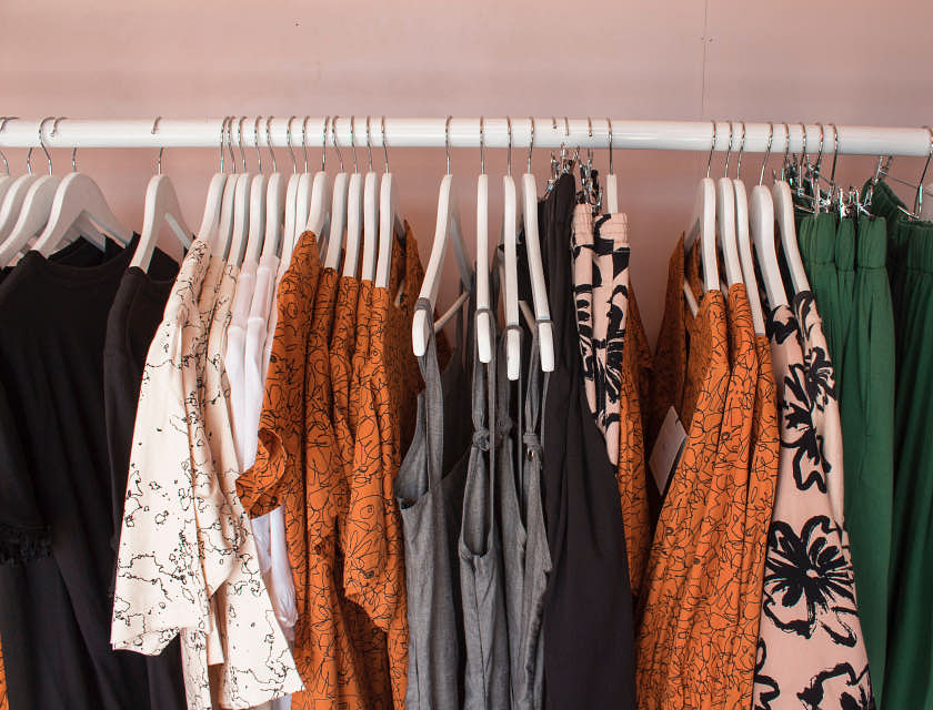 Un rack de vêtements contenant des vêtements clairs et foncés dans un magasin de location de vêtements.