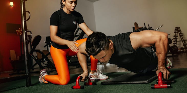 Woman coaching a man in the gym