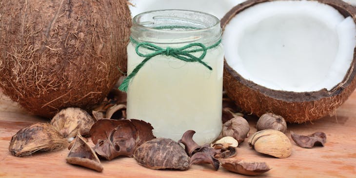 Coconuts and a jar of coconut oil on a table