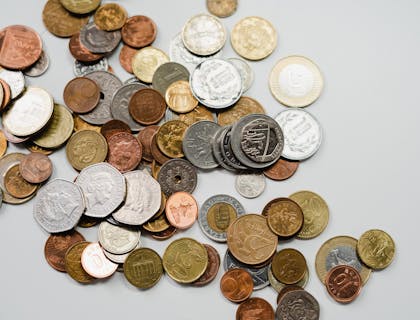 Diversas moedas diferentes em uma superfície branca.