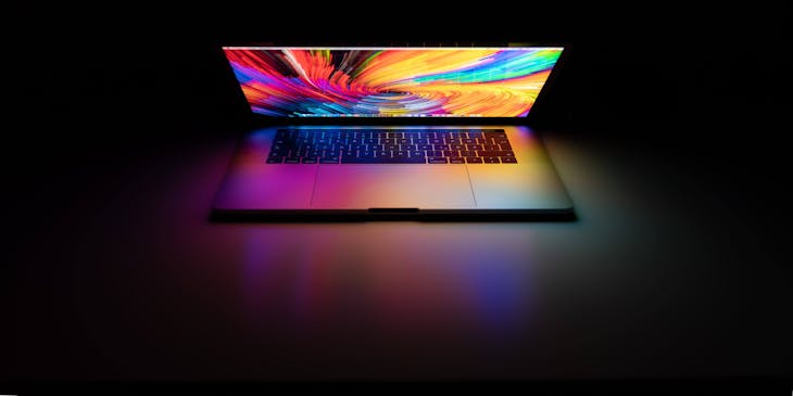 A MacBook Pro computer in a dark room.
