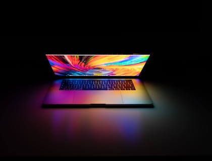 A MacBook Pro computer in a dark room.