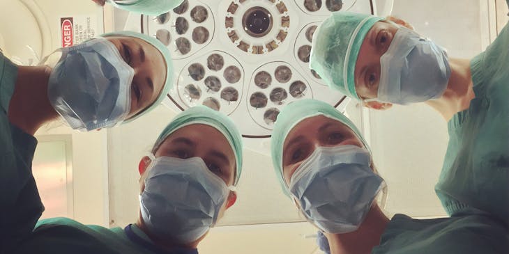 Un groupe de praticiens de la conciergerie médicale regardant vers le bas une caméra.