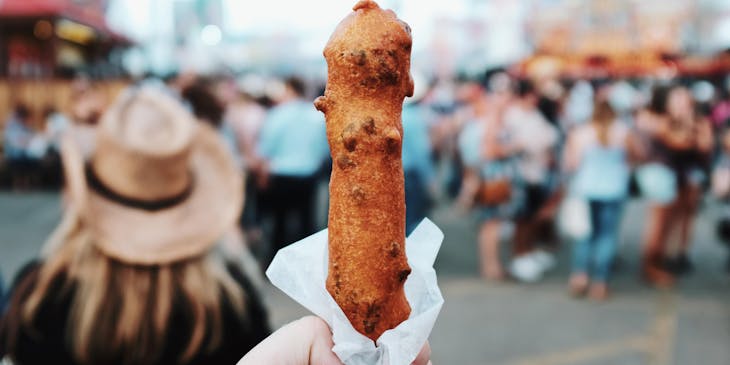 Freshly-made corn dog at a carnival.