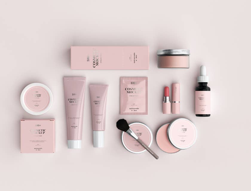 Insieme di cosmetici e accessori per il trucco, con packaging rosa sistemati con ordine su un piano bianco.