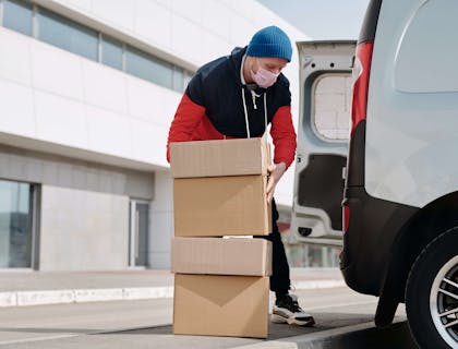 Delivery man loading packages on to a delivery van.