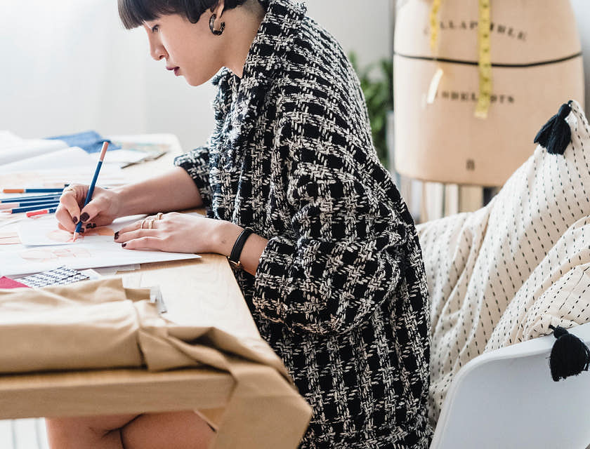 Une jeune femme dessine un croquis dans une agence créative.