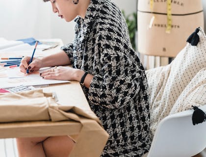 Una mujer joven dibujando un boceto en su estudio de un negocio de servicios creativos.