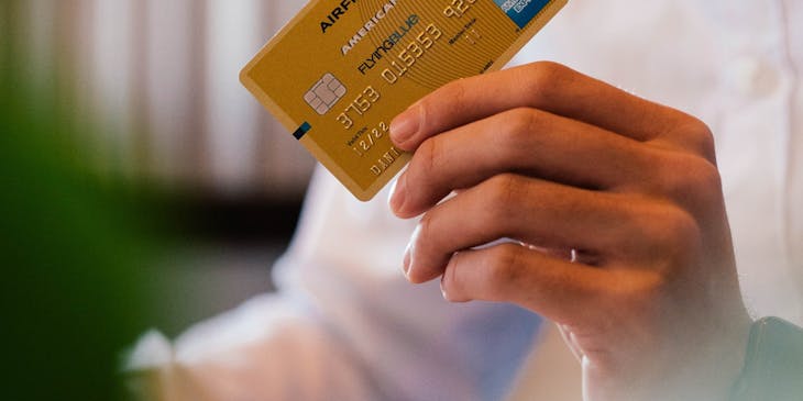A person holding a gold credit card for credit repair.