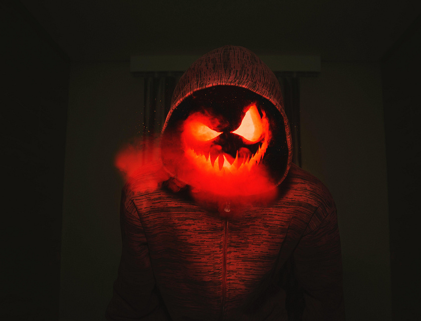 Un’inquietante zucca intagliata con una felpa rossa.