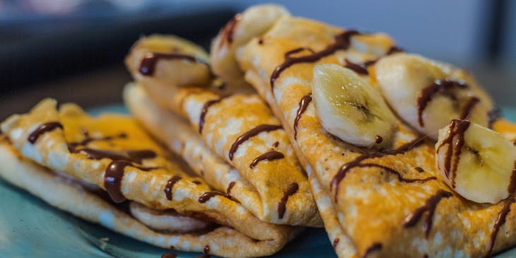 A crepe with banana on a plate at a creperie restaurant.
