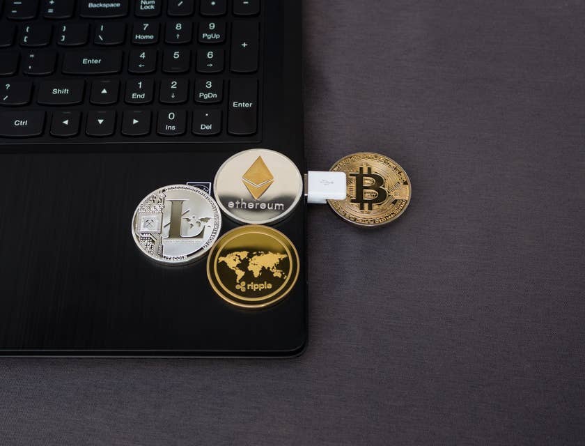 Varias monedas representado criptomonedas sobre una laptop en el escritorio de una empresa de criptomoneda.