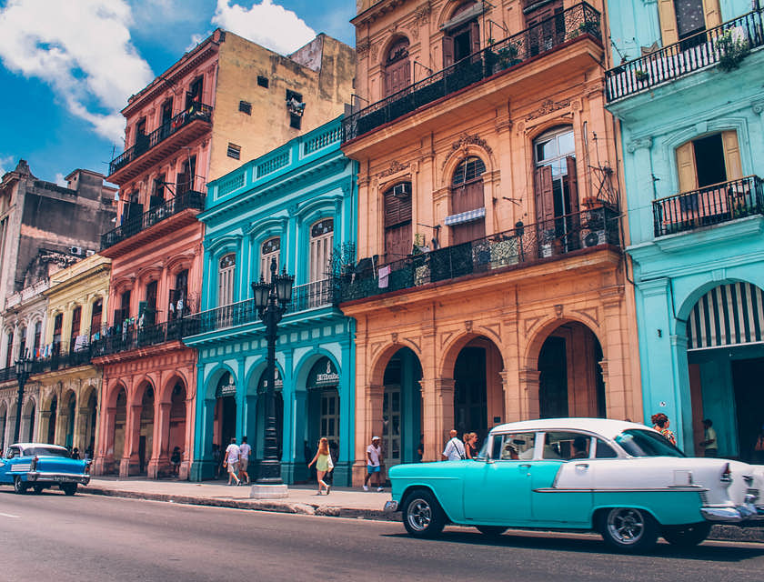 un automóvil en una calle en Cuba cerca de un negocio con nombre cubano