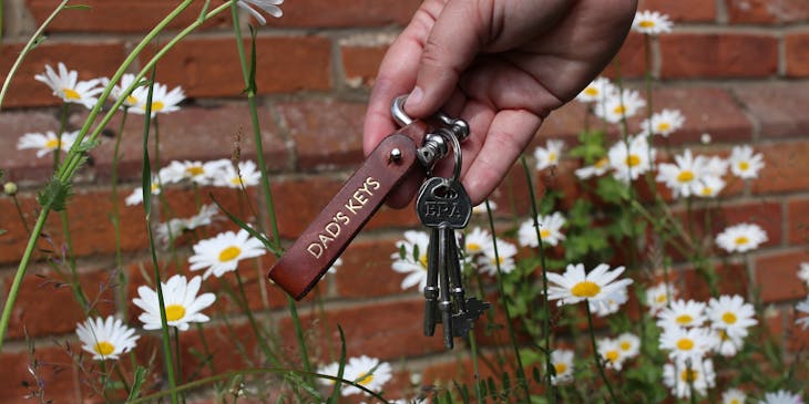 Hand holding keys with customized tag.