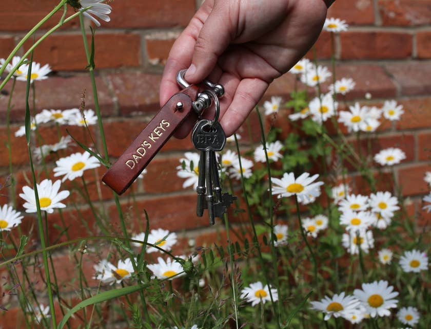 Une main tenant des clés avec une étiquette personnalisée.