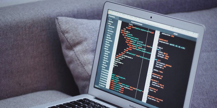 A latop displaying cyber information perched on a couch.