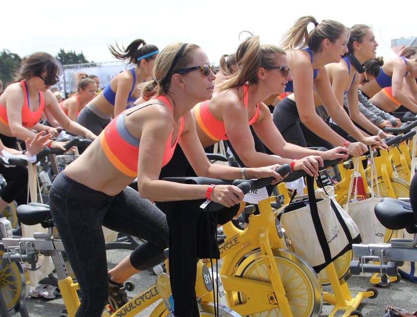 Mulheres pedalando em uma aula de spinning