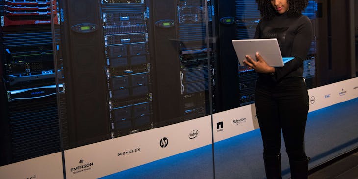 Woman standing in front of a computer server in a data recovery center.
