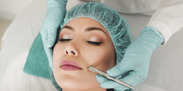 A dermatologist treating skin.