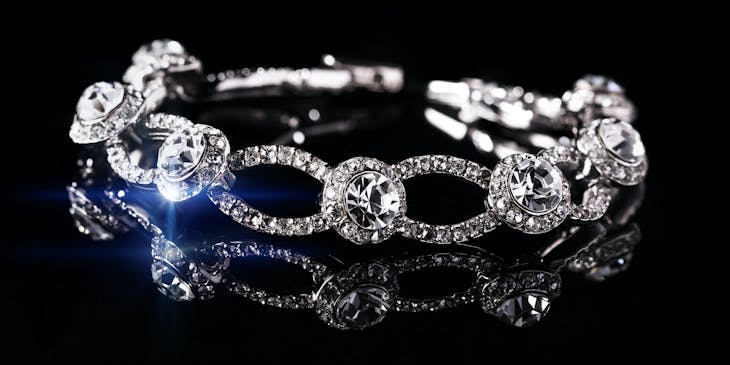 Silver and diamond bracelet on a black background.