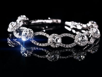 Bracelete de prata e diamantes em um fundo preto.