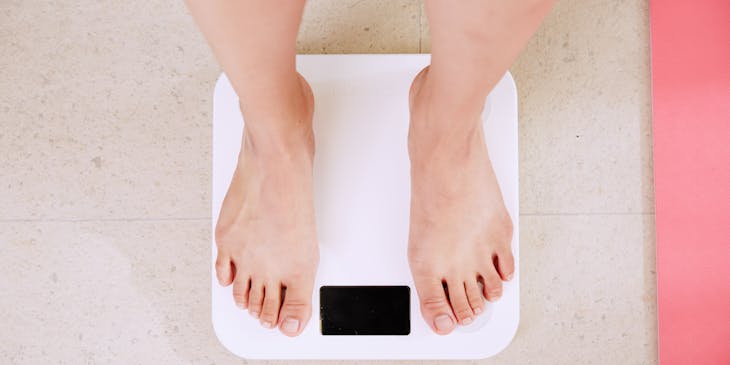 Person standing on a white scale in a dietician's office.