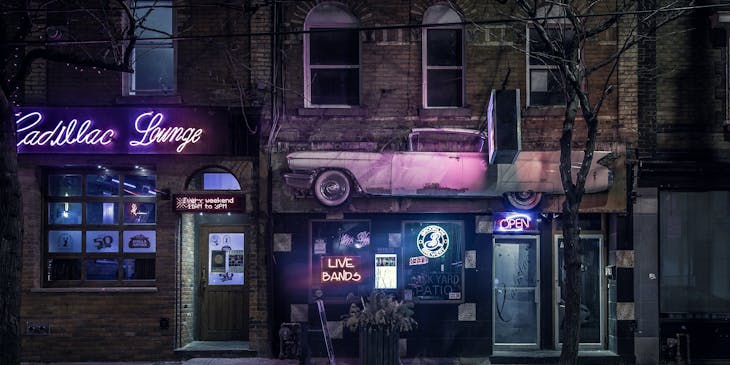 Entrance to a dive bar with neon signs.