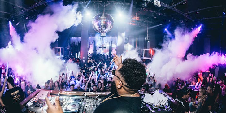 A DJ entertaining the crowd inside a dance club.