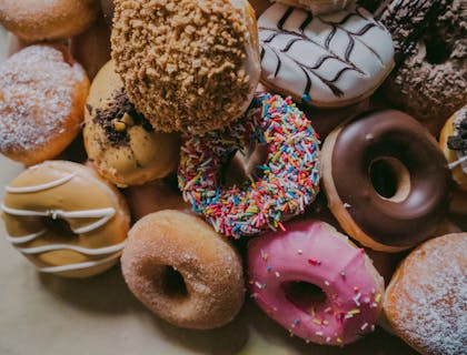 Delle ciambelle — o donuts — assortite sul bancone di un bar pasticceria.