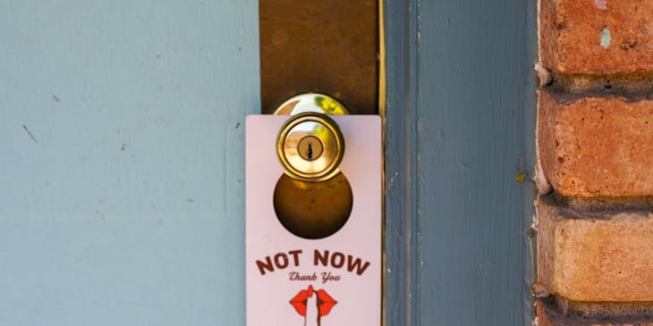 A door hanger hanging on a hotel room door.