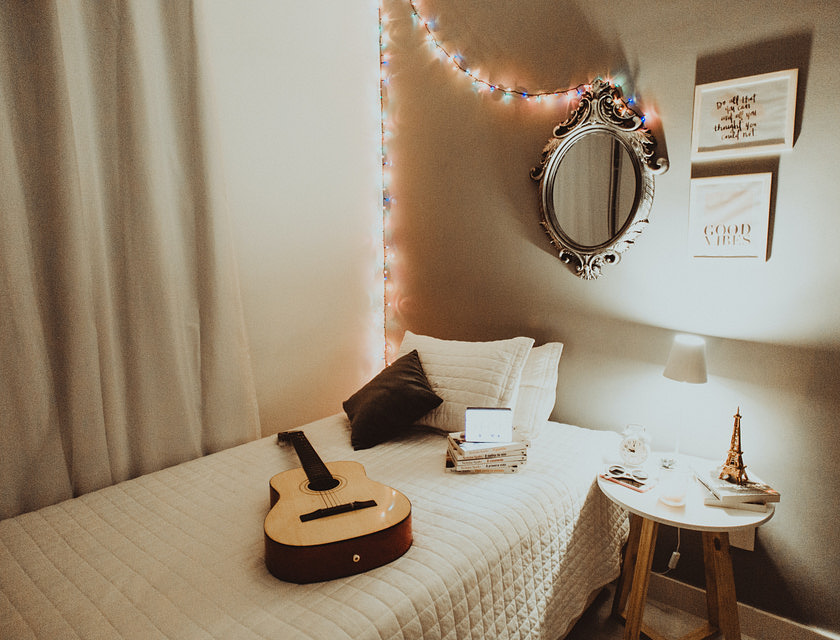 Uma cama de solteiro em um quarto de uma moradia estudantil.