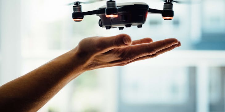 A drone hovering over a hand.