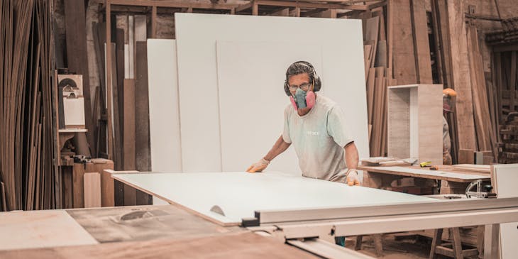 Man lifting sheet of drywall.