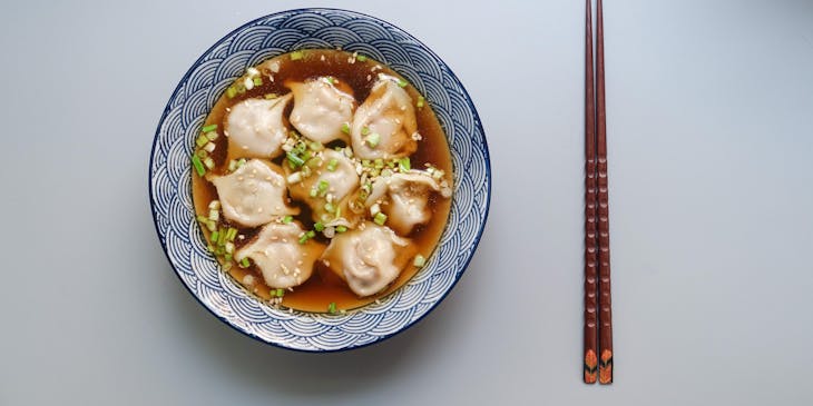 Dumplings in soup in a ceramic bowl.