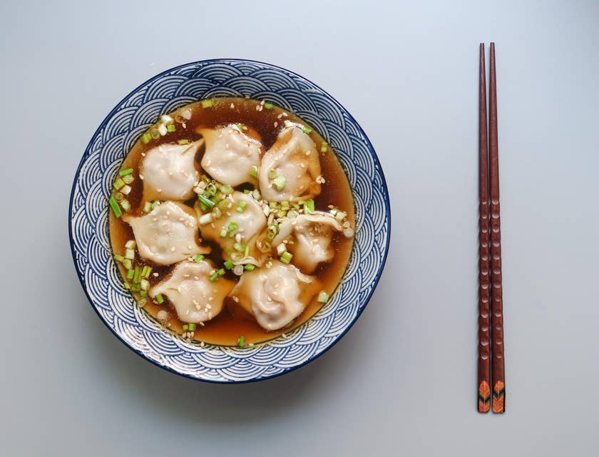 Dumplings in soup in a ceramic bowl.