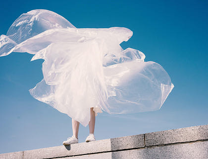 A woman posing on a rooftop in an eccentric outfit.