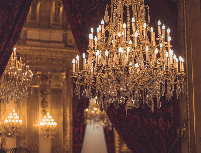 Un candelabro elegante attaccato al soffitto di una sala sfarzosa.