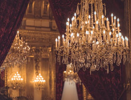 Un elegante candelabro frente a un par de cortinas de seda.