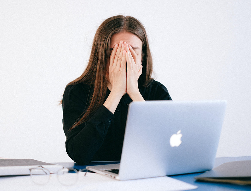 Mulher com as mãos no rosto depois que seu emprego foi encerrado ilegalmente.