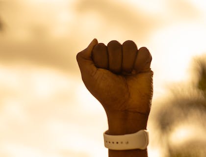 Pessoa com o punho para cima.