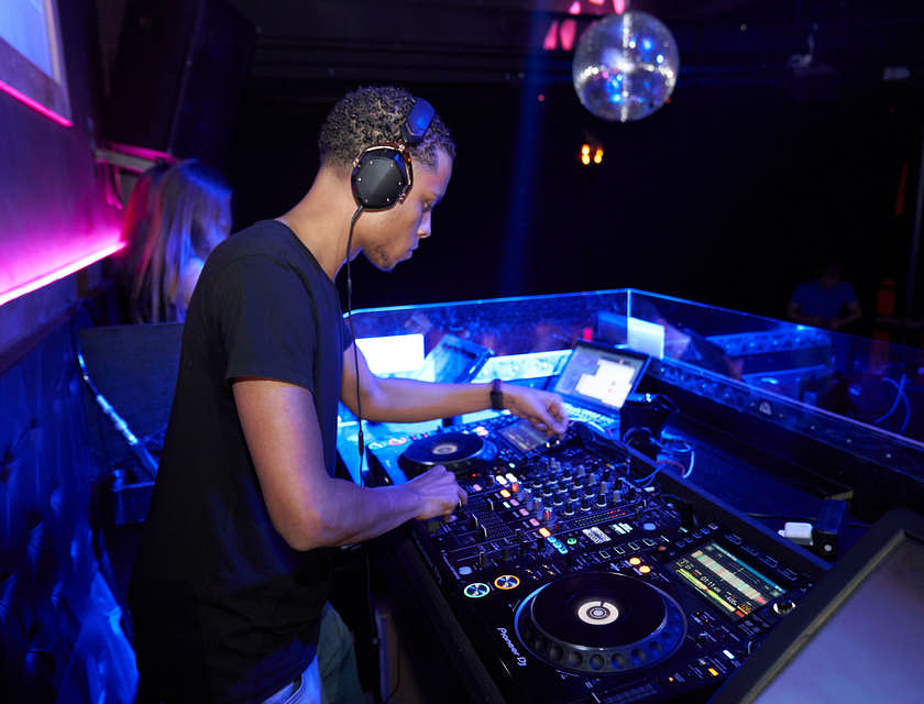 Un dj che suona alla consolle per la sua azienda di intrattenimento.